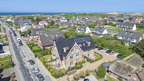 A residential area with houses, a road, and a view of the sea. - Top Lage. Design-ausstattung. Alles auf Einer Ebene für bis zu 2 Personen (Wenningstedt-Braderup (Sylt))