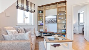 A living room with a sofa, coffee table, and a bookshelf.