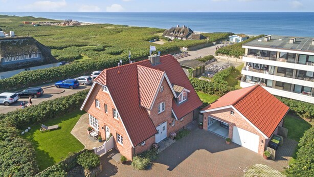 A large brick house with a red roof, a garage, and a well-maintained lawn. - Sunsets & a lot More (Wenningstedt-Braderup (Sylt))