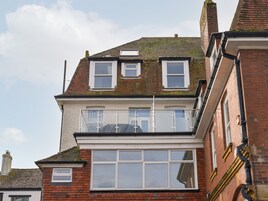 Un edificio de dos pisos con un balcón en el nivel superior.