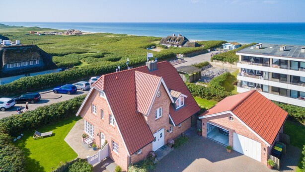 A large brick house with a red roof, a garage, and a paved driveway. - Sie Suchen Nach Einem Domizil, Dass Strandnah Gelegen Ist? (Wenningstedt-Braderup (Sylt))