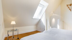 A bedroom with a skylight, a bedside table with a lamp, and a bed. - Sie Suchen Nach Einem Domizil, Dass Strandnah Gelegen Ist? (Wenningstedt-Braderup (Sylt))