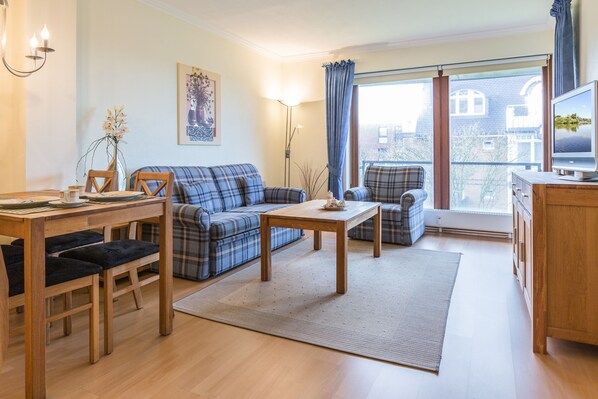 Relax in a comfortable seating area with a sofa, armchair, and dining table.
