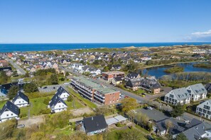 Et kystnære boligområde med huse, parkeringsplads og vand.