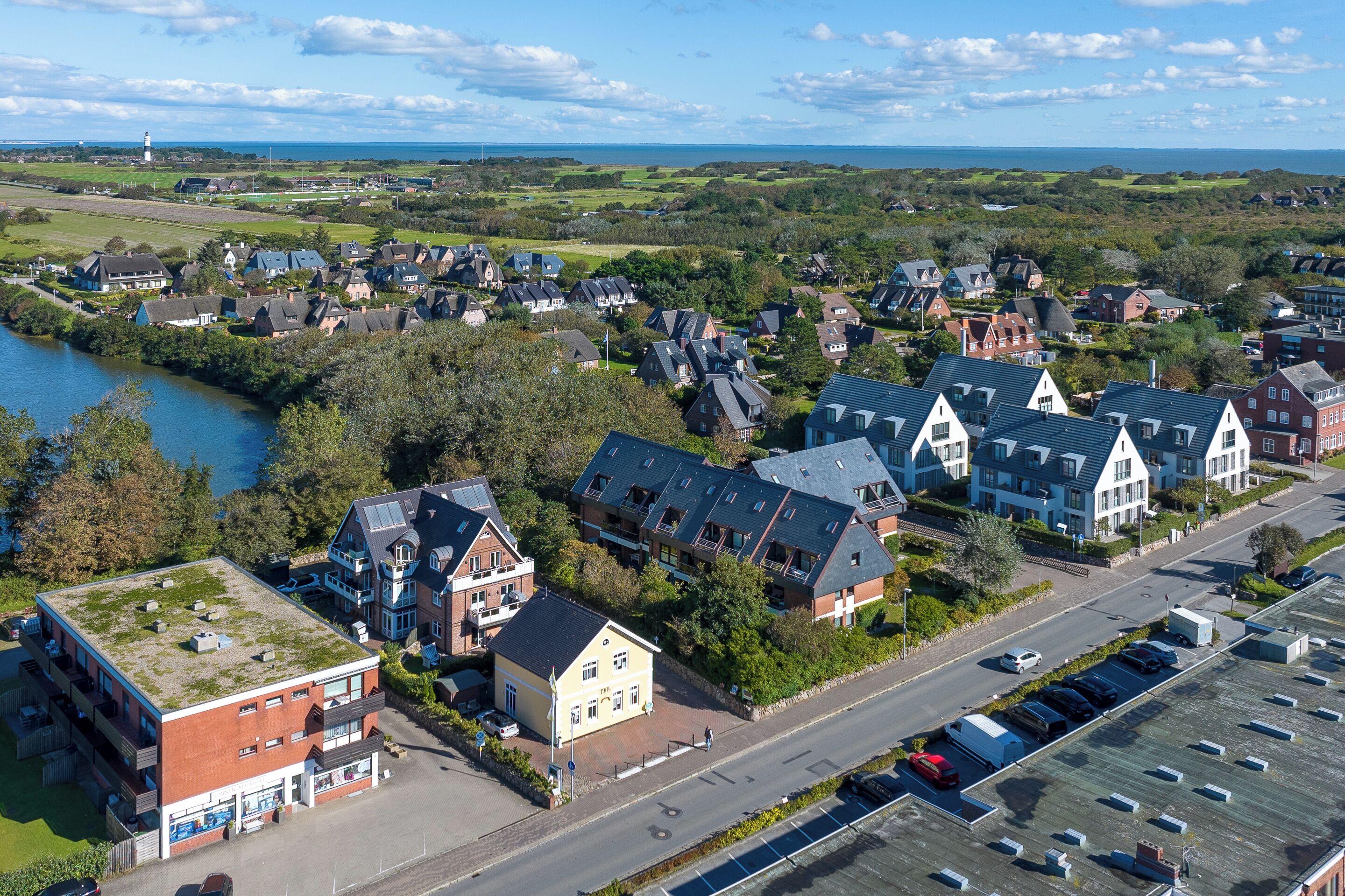 Un quartier résidentiel comprenant des maisons, un parking et une étendue d’eau.