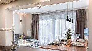 Eine moderne Küche mit Essbereich, einer Couch und Blick ins Freie.