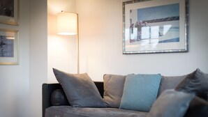 A modern living room with a sofa, a floor lamp, and a framed picture on the wall. - Sylt. Heide. Und Meer (Wenningstedt-Braderup (Sylt))