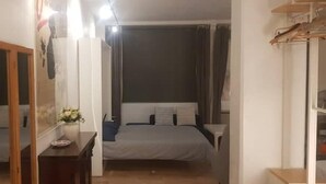 Ein Schlafzimmer mit Bett, Kommode und Spiegel.