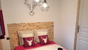 Una cama bien hecha con una colcha estampada, dos almohadas decorativas y un cabecero.