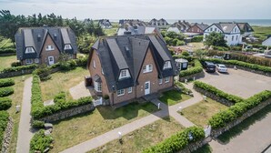 A residential area with houses featuring steep gabled roofs and brick exteriors. - First-class Suiten in Bestlage (Wenningstedt-Braderup (Sylt))