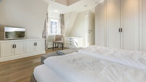 A bedroom with a large bed, a desk, and a wardrobe. - In Bester, Strandnaher Lage Gelegenes, Freistehendes Luxus-haus Unter Reet (Wenningstedt-Braderup (Sylt))
