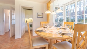 A dining area with a round table set for six, surrounded by wooden chairs. - De-luxe village pond flair. (Wenningstedt-Braderup (Sylt))