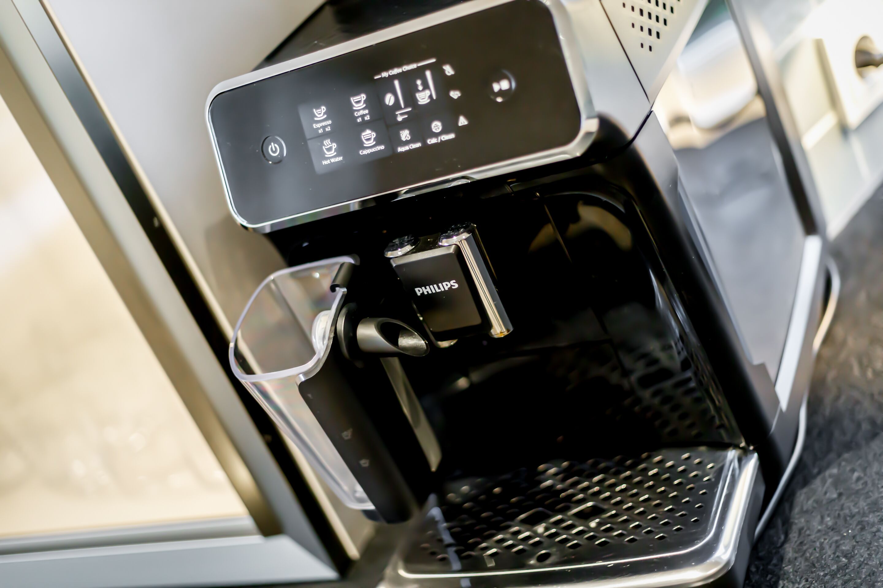 A coffee machine with a digital display and a cup holder.