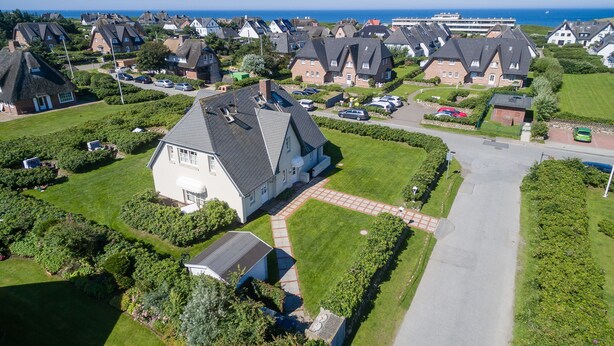 A residential area with houses featuring steep roofs and a well-maintained lawn. - Completely ground floor 3-room apartment near the beach. (Wenningstedt-Braderup (Sylt))