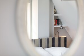 Un dormitorio con una cama, una estantería y una lámpara.