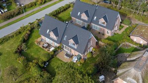 A large, two-story house with a well-maintained lawn and a driveway leading to the front entrance.