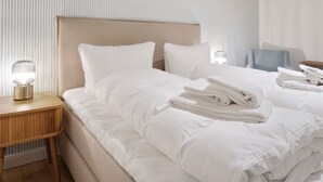 A hotel room with a large bed, a bedside table with a lamp, and a chair.