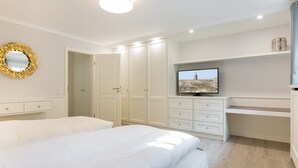Un dormitorio con dos camas, televisión y armarios empotrados.