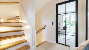Eine moderne Treppe mit Holzdielen und einer Glastür zu einer Terrasse.
