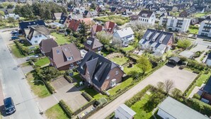 An aerial view of a residential area with houses, a clear sky, and a road. - Zentral, Aber Dennoch Sehr Ruhig und Strandnah Gelegen (Wenningstedt-Braderup (Sylt))