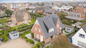 Un quartier résidentiel où les maisons présentent différents styles de toits et où les jardins sont bien entretenus.