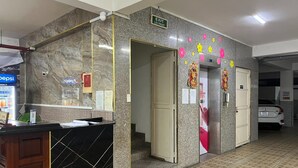 A hotel reception area with a marble counter, a Pepsi refrigerator, and a car parked outside. - Capital O 1221 Thien An Hotel (Ho Chi Minh City)