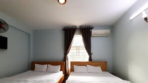 A room with two single beds, a flat-screen TV on the wall, and an air conditioning unit. - Capital O 1221 Thien An Hotel (Ho Chi Minh City)