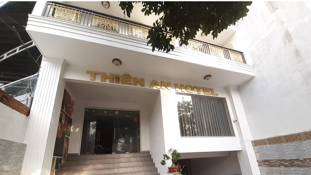 The entrance of Thien An Hotel with a staircase leading up to the entrance, potted plants, and a balcony with a railing. - Capital O 1221 Thien An Hotel (Ho Chi Minh City)