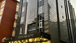 A modern hotel with a glass facade, multiple floors, and a ground-level entrance with outdoor seating. - Ardos Park Hotel (Ankara)