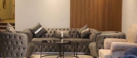 A modern living room with a sectional sofa, two armchairs, and a coffee table.