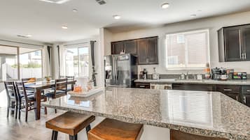 A modern kitchen with dark wood cabinets, a granite countertop, and stainless steel appliances.