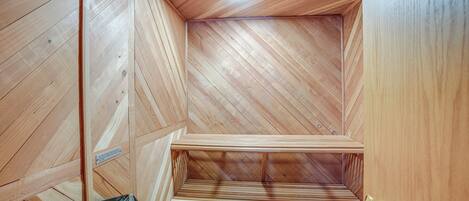 A wooden interior with a sloped ceiling and a built-in bench.