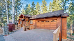A wooden cabin with a garage, stone fireplace, and a stone wall. - 4 Mi to Slopes: Family-friendly Stateline Home! (Stateline)