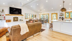 A spacious living area with a fireplace, a large TV, and a dining area with a view of the outdoors. - 4 Mi to Slopes: Family-friendly Stateline Home! (Stateline)