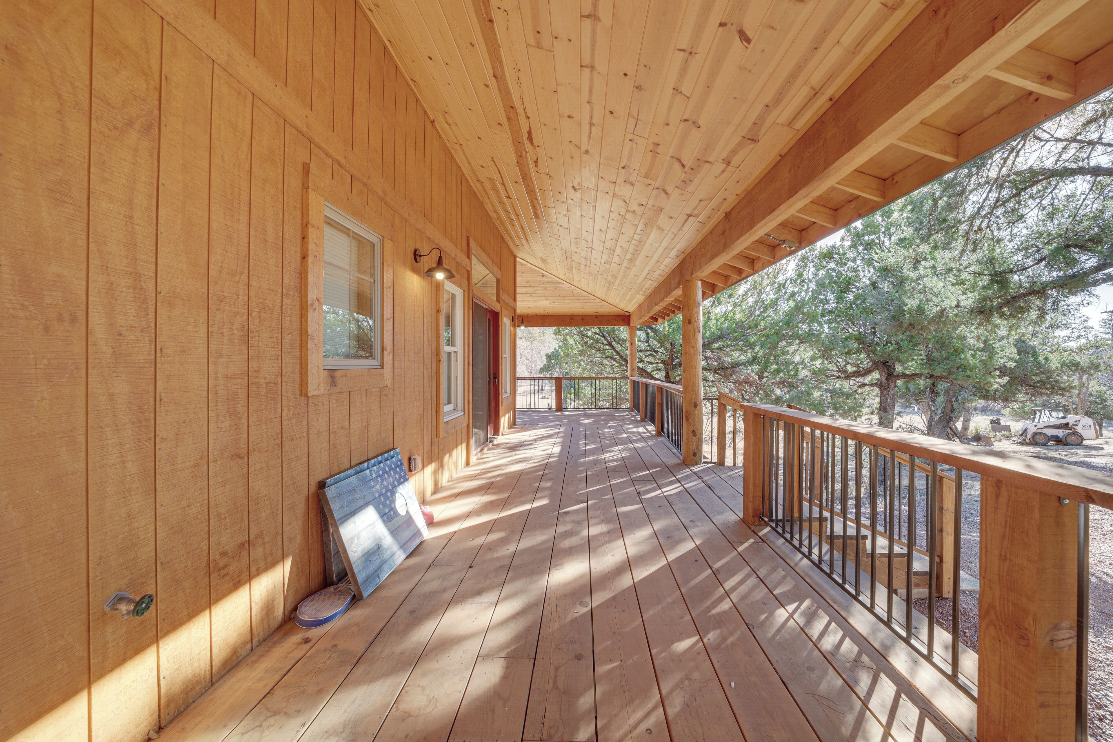 A wooden deck with a railing, a window, and a door.