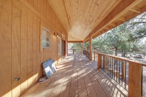 A wooden deck with a railing, a window, and a door.