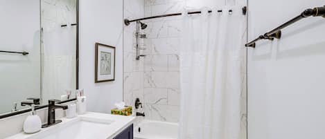 Ein modernes Badezimmer mit einem weißen Waschbecken, einem schwarzen Wasserhahn und einer weißen Toilette.