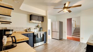 A modern kitchen with a built-in oven, microwave, and coffee maker. There is a wooden countertop and a ceiling fan. - Charming State College Home - 4 Mi to Psu! (State College)