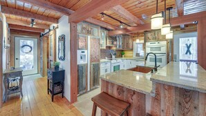 A spacious kitchen with wooden beams, a large island, and modern appliances.