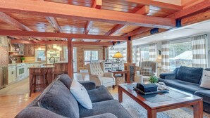 A spacious living area with a sofa, coffee table, and a kitchen in the background.