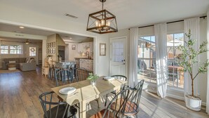 A spacious dining area with a wooden table, metal chairs, and a hanging light fixture. - Game Room & Fire Pit: Family-friendly Aubrey Home (Aubrey)