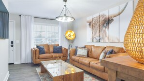 A modern living room with two brown leather sofas, a glass coffee table, and a wooden side table. - Modern Townhome: Walk to Tennessee Tech University (Cookeville)