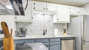 A modern kitchen with white cabinets, a herringbone tile backsplash, a stainless steel refrigerator, and a dishwasher. - Modern Townhome: Walk to Tennessee Tech University (Cookeville)