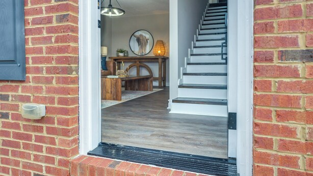 A staircase leading to a second floor, a wooden bench, a lamp, and a mirror on the wall. - Modern Townhome: Walk to Tennessee Tech University (Cookeville)