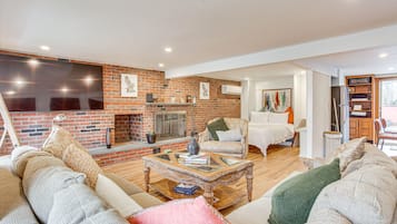 Appartement (0 Bedroom) | Woonruimte | Een televisie, een open haard en boeken