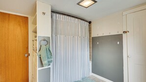 Ein Badezimmer mit Duschvorhang, Handtuchhalter und Tür.