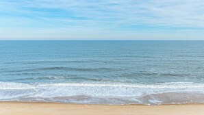 A beach with a clear view of the ocean and a sandy shore.