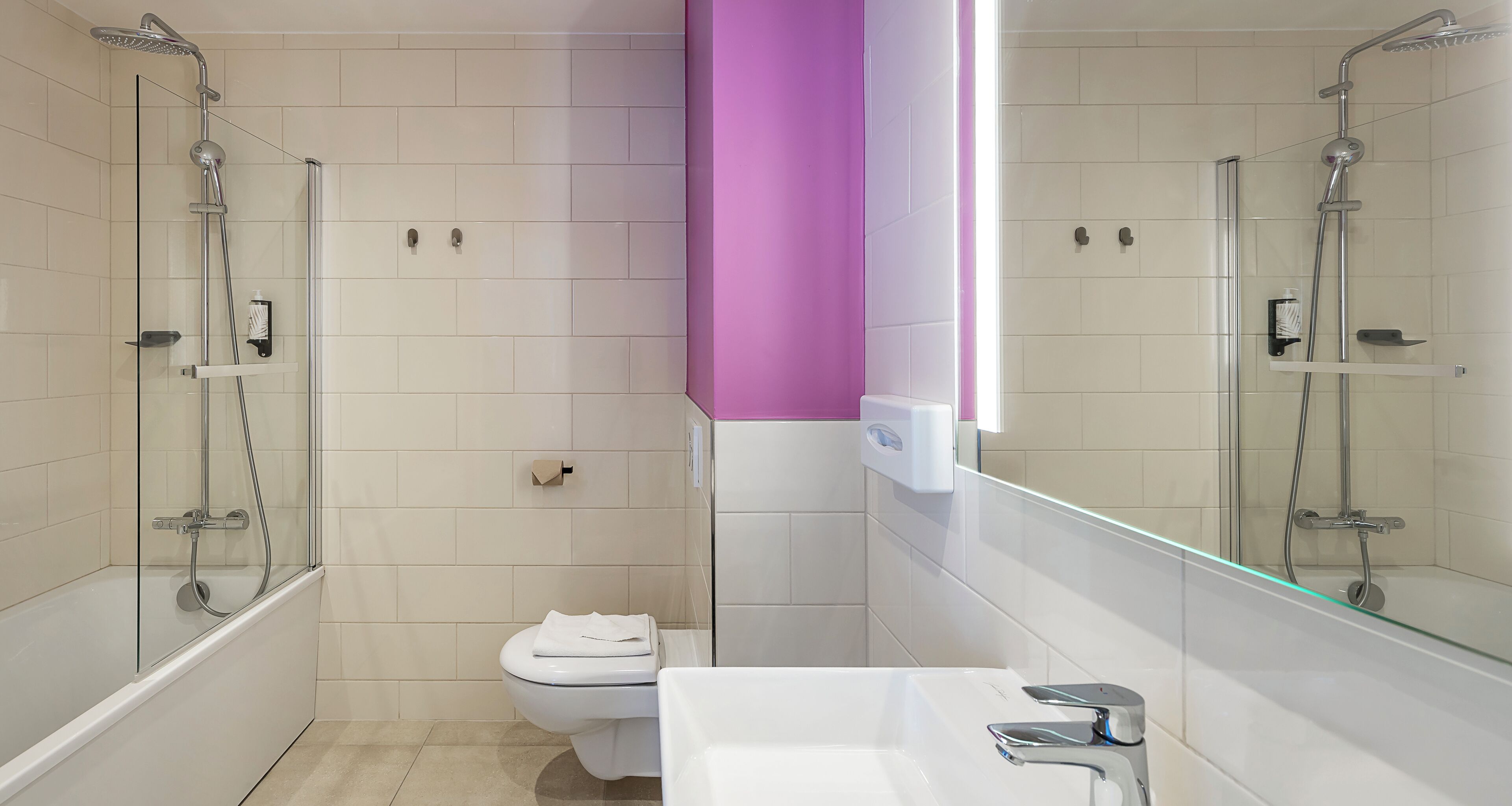 A modern bathroom with a glass-enclosed shower, a white toilet, and a white sink with a chrome faucet.