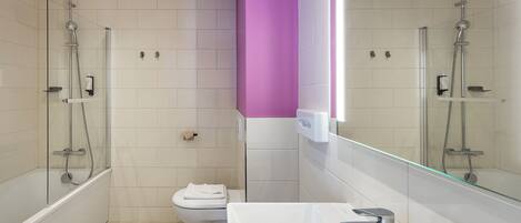 Un bagno moderno con doccia vetrata, un WC bianco e un lavandino bianco con rubinetto cromato.