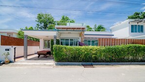 A modern two-story house with a pool, a fenced backyard, and a well-maintained garden.